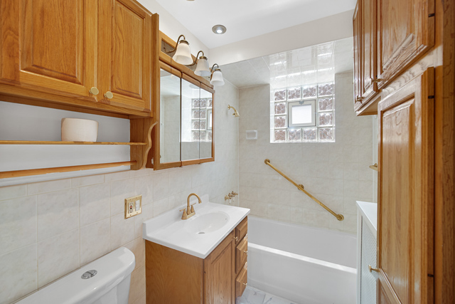 1007 South Austin Boulevard, Unit 1 Chicago, IL 60644 - Photo 8 of 15 a bathroom with a sink a vanity and a bathtub