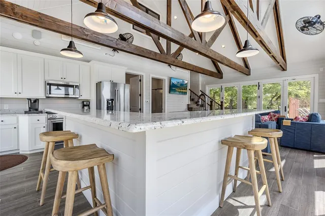 a kitchen with stainless steel appliances granite countertop wooden floors and sink
