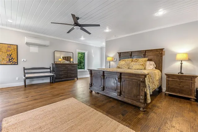 a kitchen with stainless steel appliances kitchen island granite countertop a stove and white cabinets with wooden floor