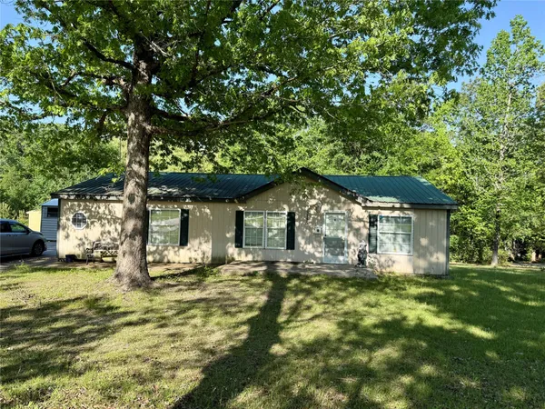 a front view of house with yard and trees around