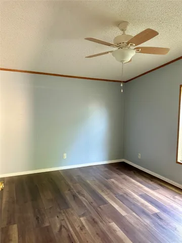 en empty room with wooden floor and fan