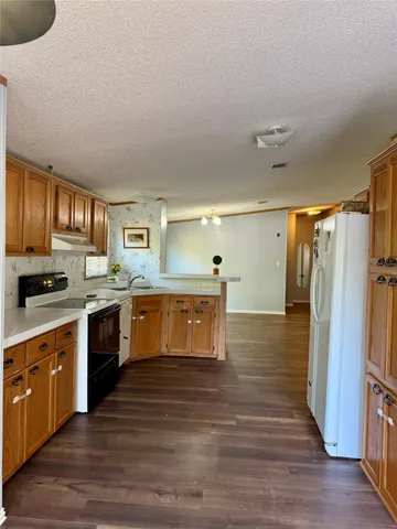 a kitchen with stainless steel appliances granite countertop a stove a sink dishwasher and a refrigerator