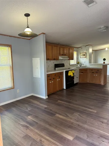 a large kitchen with cabinets wooden floor and stainless steel appliances
