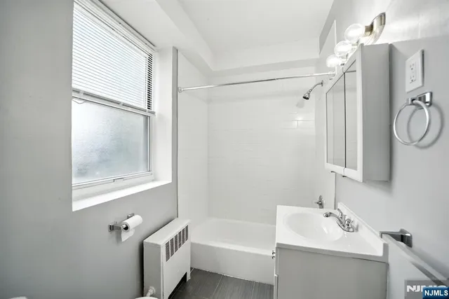 a bathroom with a tub a sink and a window