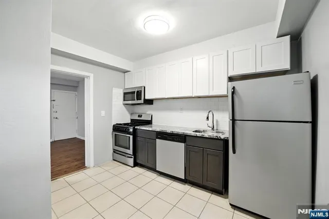 a kitchen with stainless steel appliances granite countertop white refrigerator stove a sink and dishwasher