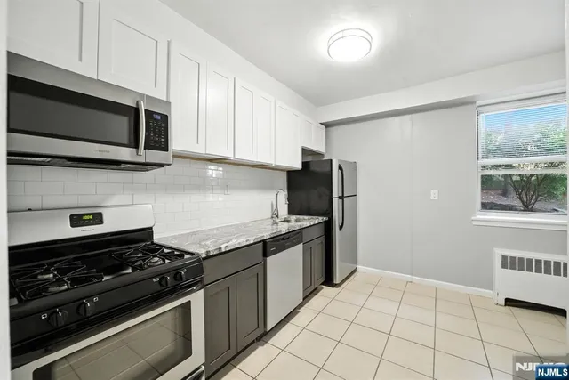 a kitchen with stainless steel appliances a sink a stove a microwave and cabinets