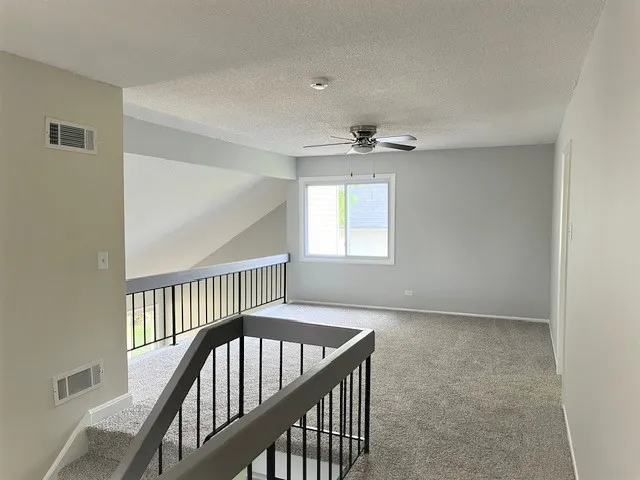 a view of an entryway wooden floor and chandelier