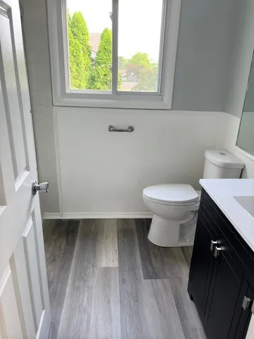 a bathroom with a sink toilet and a window