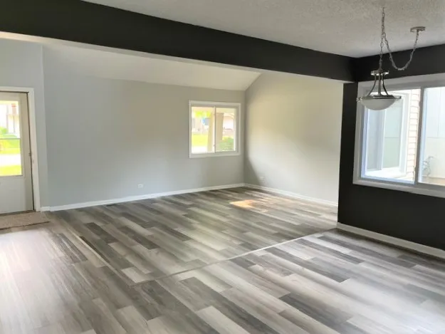 a view of a room with wooden floor and windows