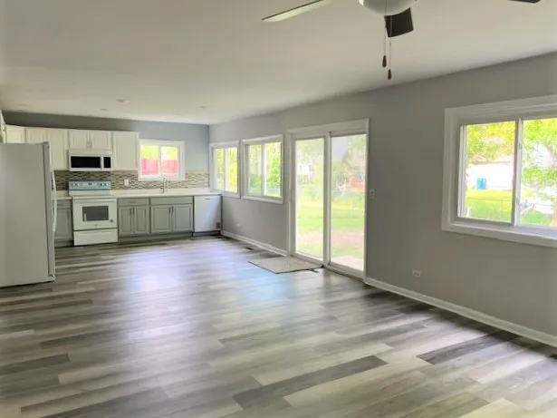 a kitchen with stainless steel appliances granite countertop a stove top oven a sink with wooden floors and large cabinets