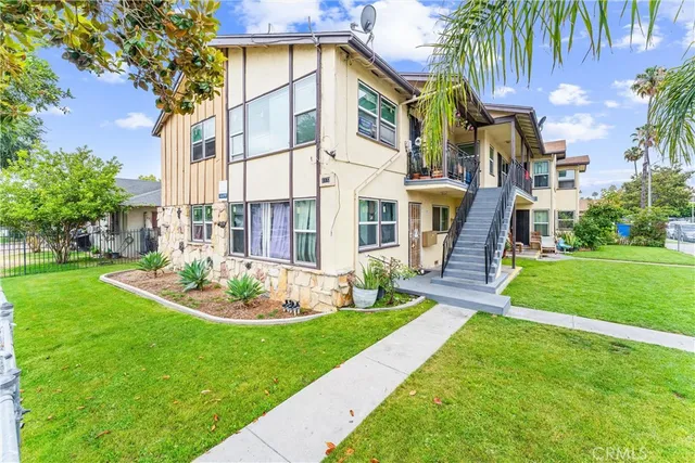 a view of a white house with a yard table and chairs