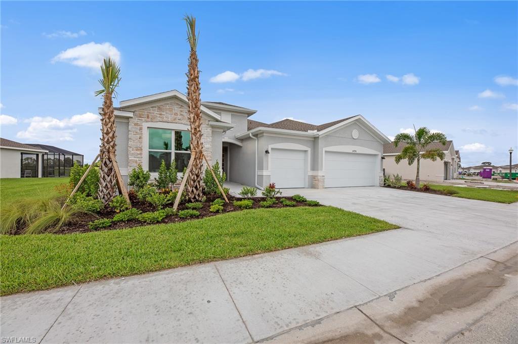 20790 Copperhead Drive Lehigh Acres, FL 33936 - Photo 34 of 36 a front view of a house with a yard and potted plants