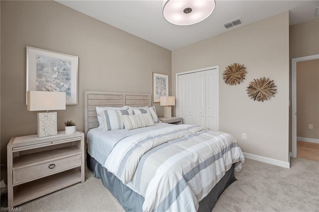 20790 Copperhead Drive Lehigh Acres, FL 33936 - Photo 5 of 36 a bedroom with a bed and a lamp on dresser