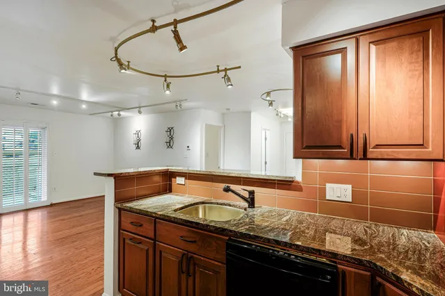 a bathroom with a granite countertop sink a mirror and shower