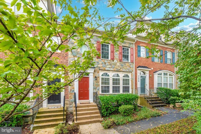 a front view of a house with a tree