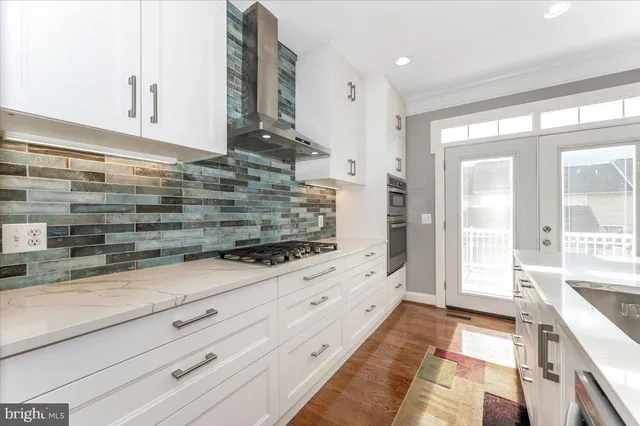 a kitchen with granite countertop white cabinets and stainless steel appliances