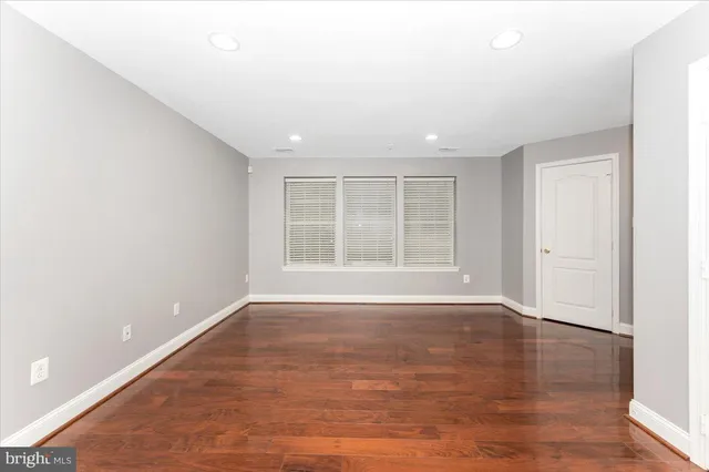 an empty room with wooden floor and fireplace