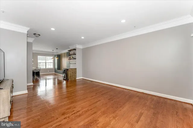 a view of empty room with wooden floor and fireplace