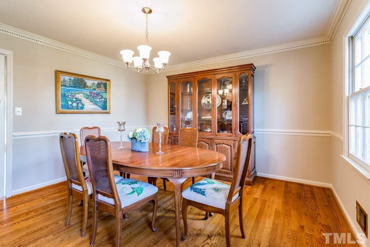 7616 Harps Mill Road Raleigh, NC 27615 - Photo 6 of 24 Hardwood floors, new brushed nickel chandelier, chair rail and crown molding are fine features of the large dining room.