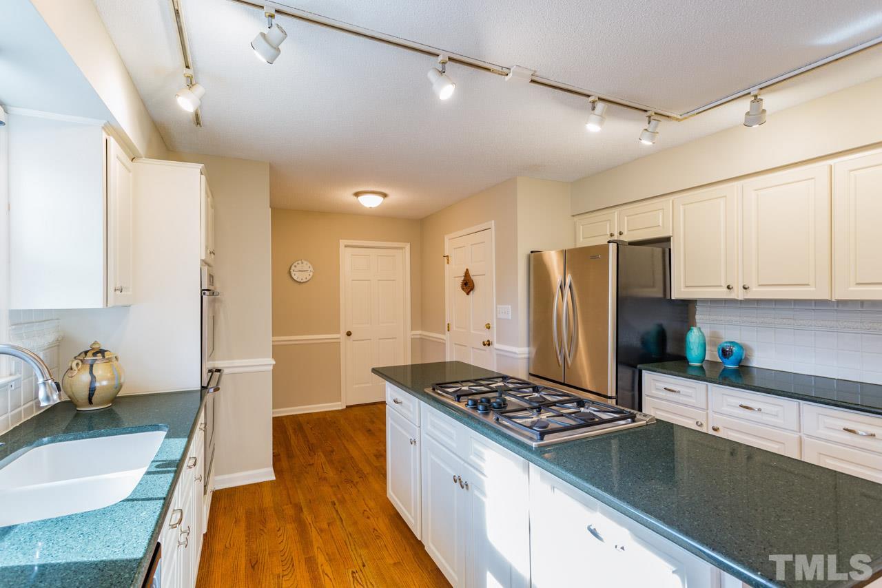 7616 Harps Mill Road Raleigh, NC 27615 - Photo 9 of 24 The freshly painted kitchen offers a long central island with gas cook top.