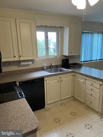 a kitchen with granite countertop white cabinets and sink