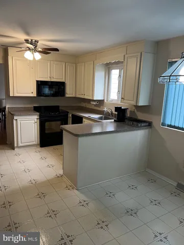 a kitchen with a sink a stove and cabinets