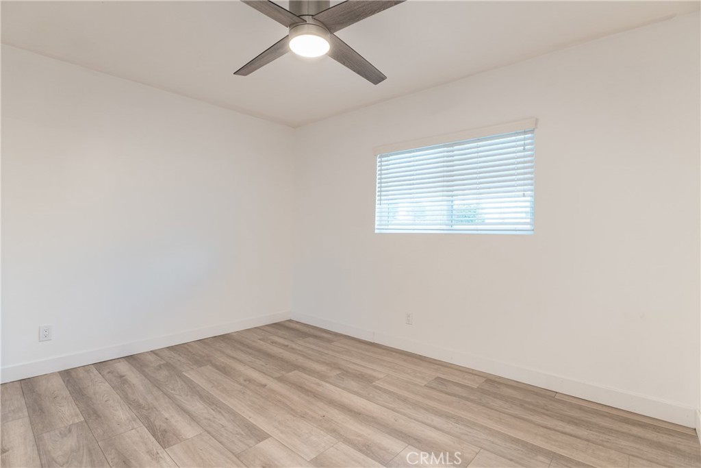 7348 Florence Avenue, Unit 4 Downey, CA 90240 - Photo 6 of 16 an empty room with a window and wooden floor