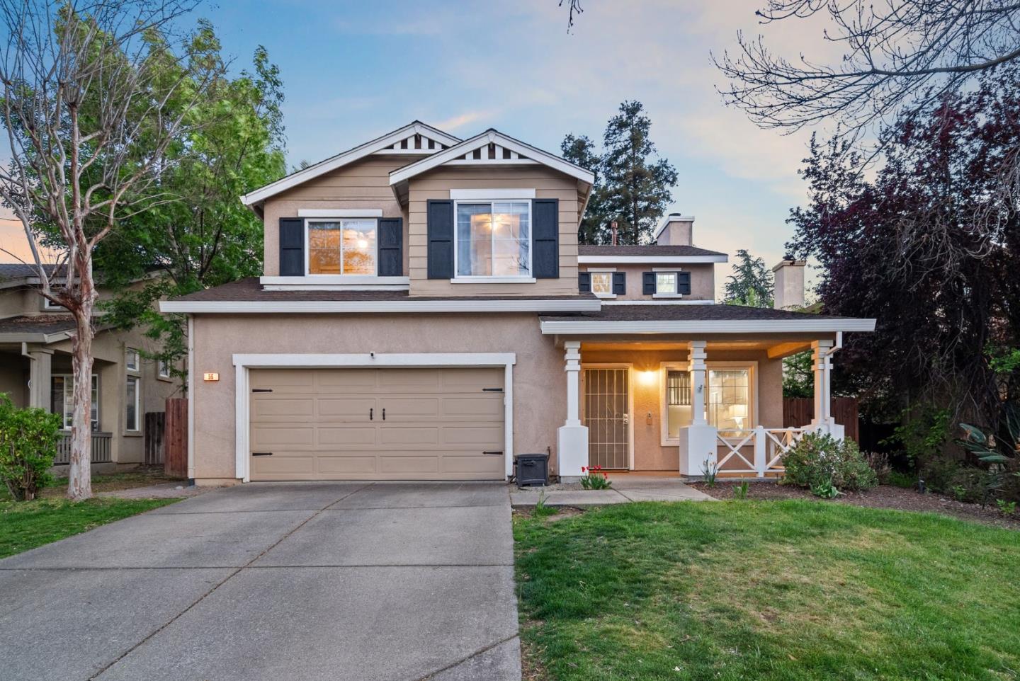 a front view of a house with a garden and trees