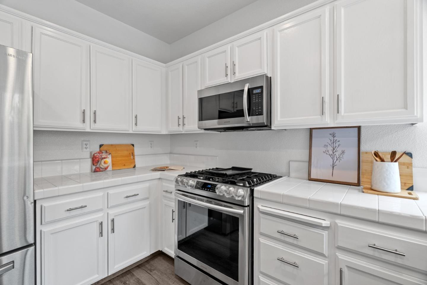 56 Lavender Court Tracy, CA 95376 - Photo 14 of 56 a kitchen with white cabinets and white appliances