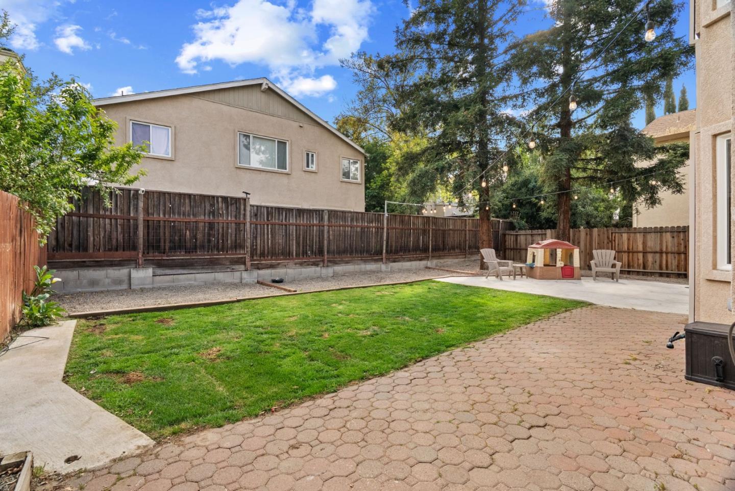 56 Lavender Court Tracy, CA 95376 - Photo 35 of 56 a view of a white house with a small yard and a large tree