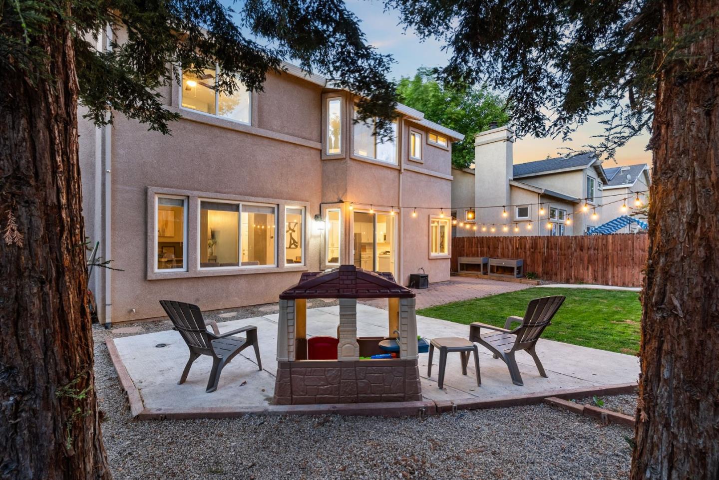 56 Lavender Court Tracy, CA 95376 - Photo 53 of 56 a view of a patio with a table and chairs under an umbrella with large trees