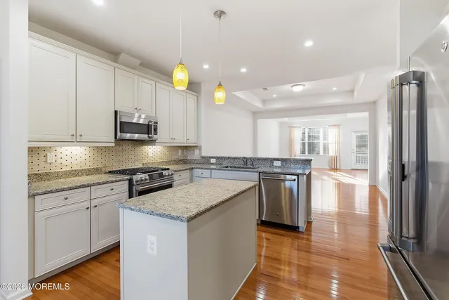 a kitchen with stainless steel appliances granite countertop a refrigerator sink and stove
