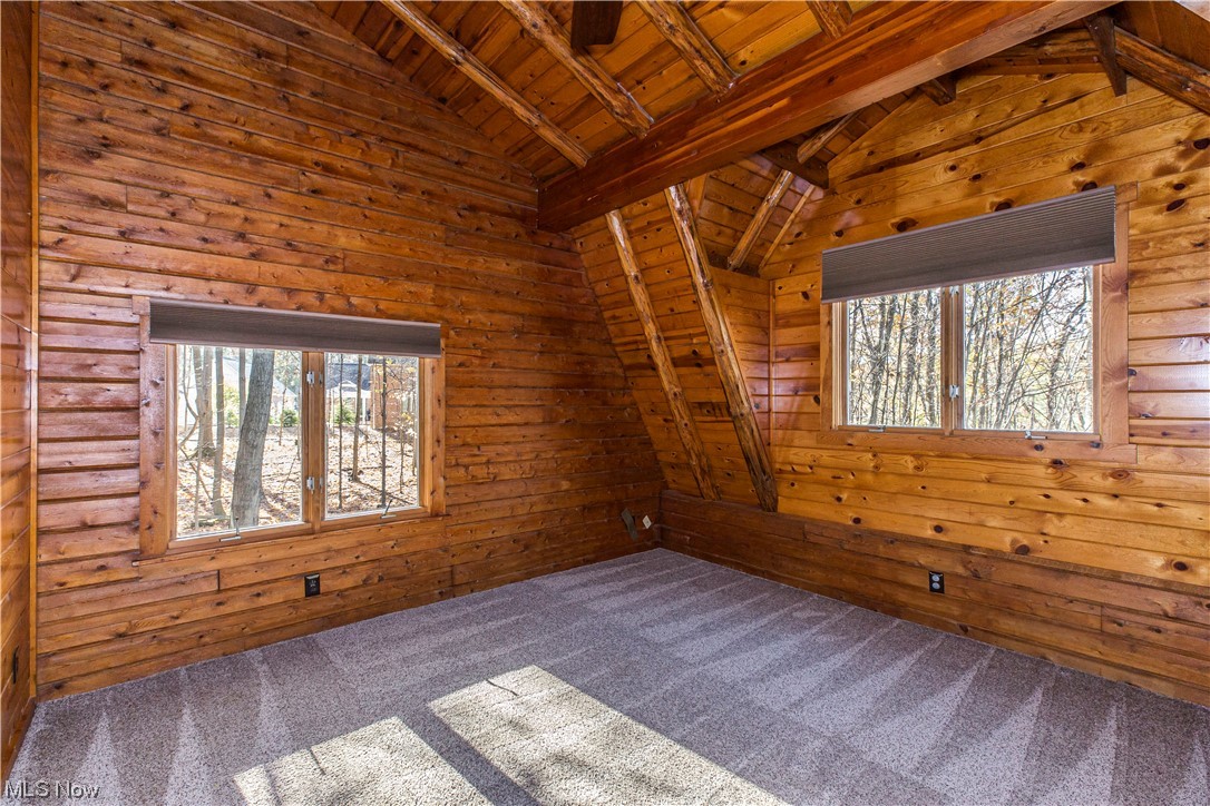 4069 Erhart Road Medina, OH 44256 - Photo 20 of 30 Empty room featuring wooden walls, carpet, lofted ceiling with beams, and wooden ceiling