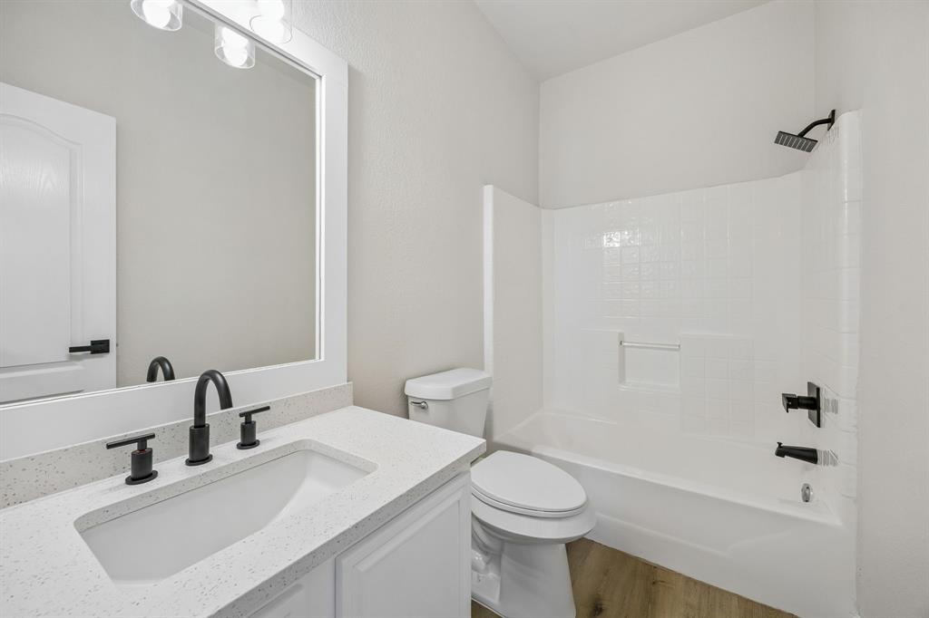 13347 Dove Ranch Road Fort Worth, TX 76262 - Photo 25 of 30 White vanity with integrated sink, black fixtures, and a speckled countertop