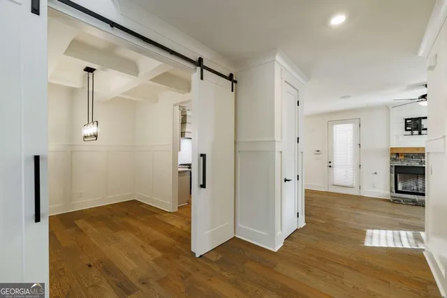 a view of a hallway with wooden floor and a living room