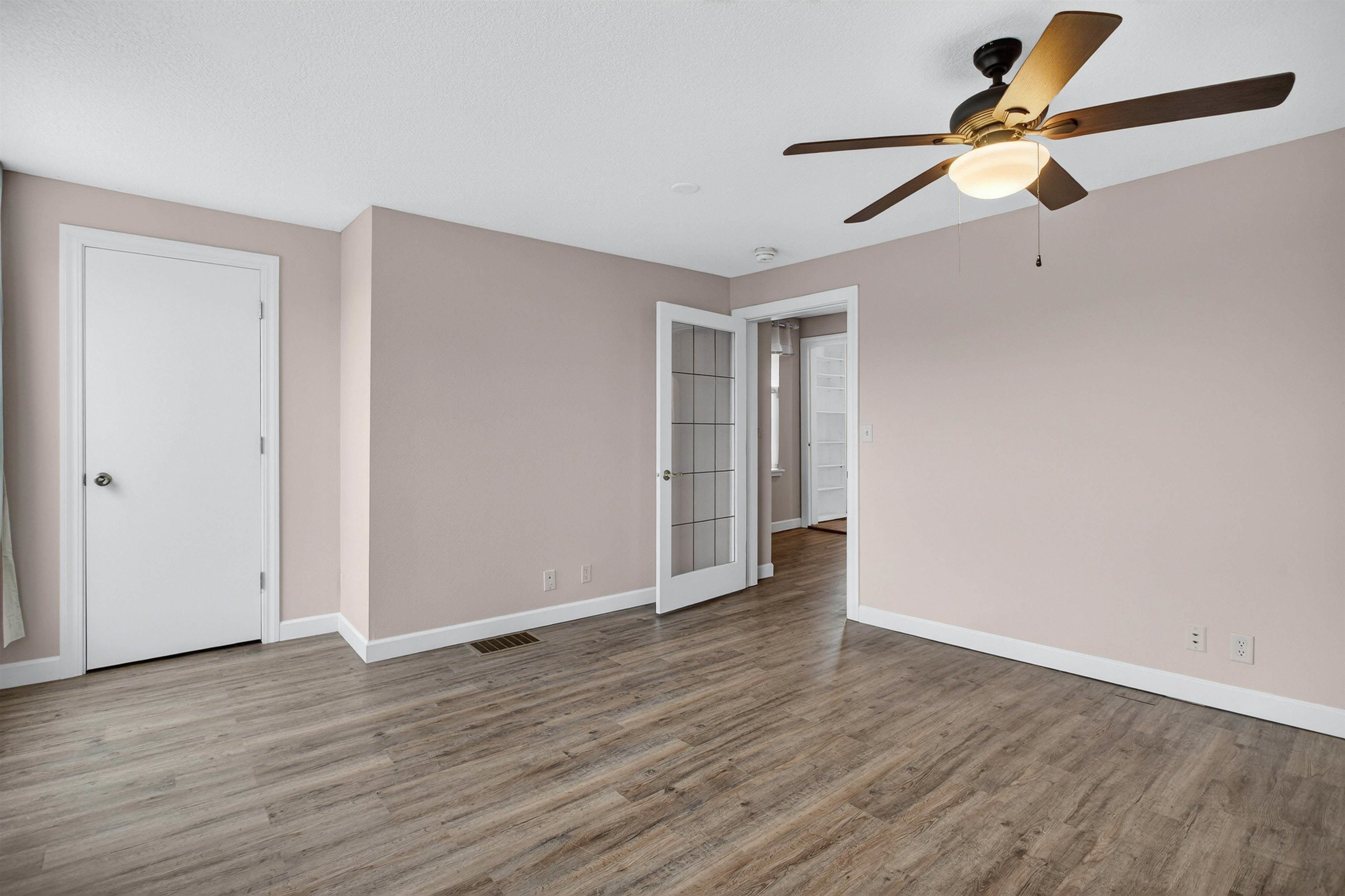118 North Cody Road Leclaire, IA 52753 - Photo 31 of 42 an empty room with wooden floor ceiling fan and window