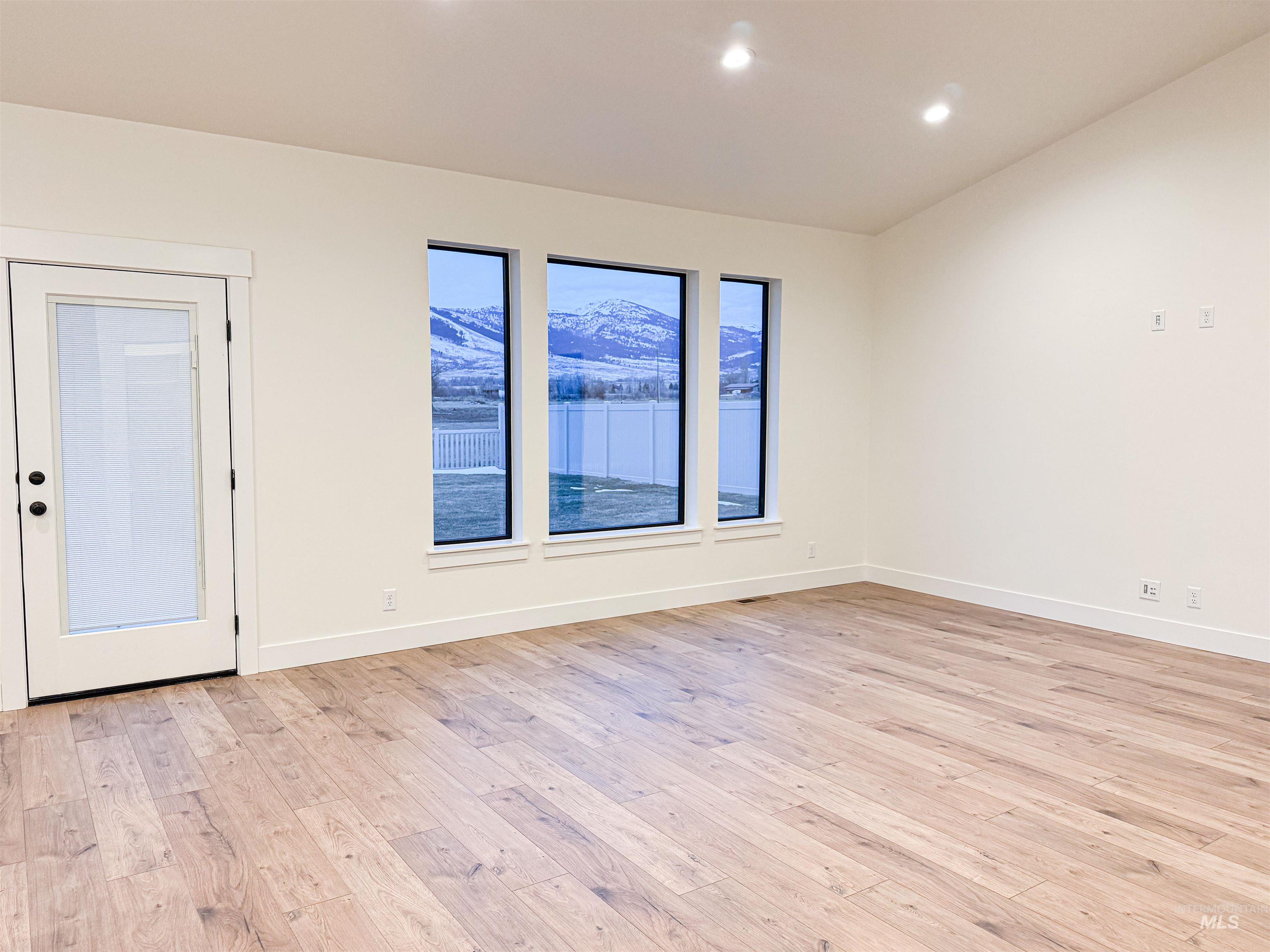 235 Whitman Street Albion, ID 83311 - Photo 4 of 23 Unfurnished room featuring light wood finished floors, a mountain view, and recessed lighting