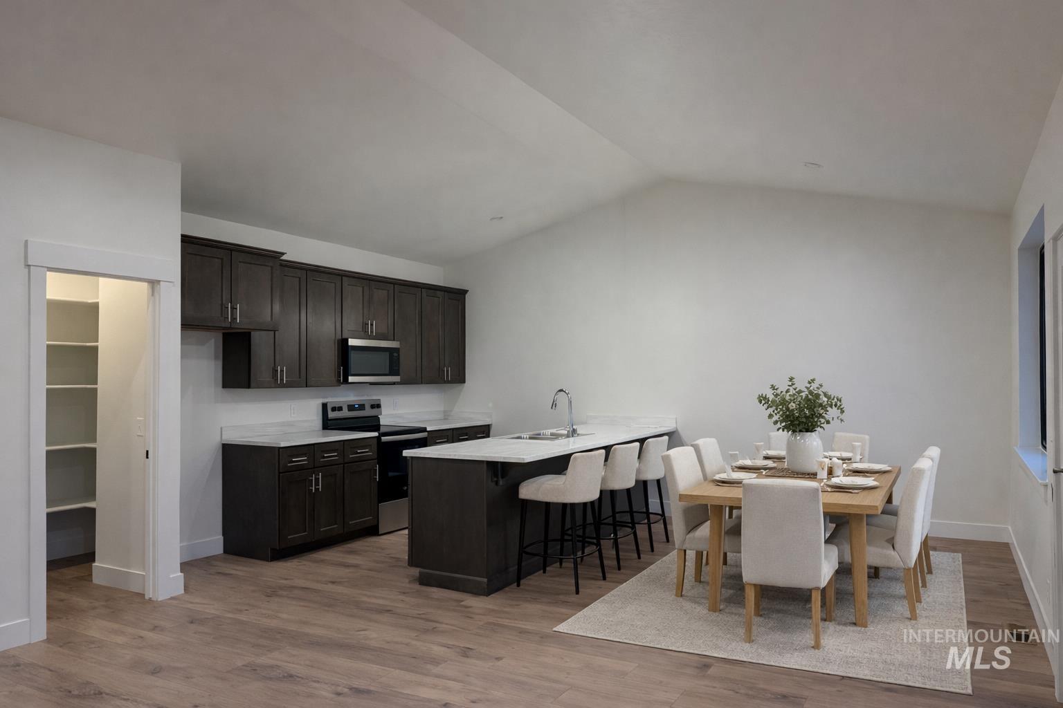 235 Whitman Street Albion, ID 83311 - Photo 6 of 23 Kitchen with stainless steel appliances, a kitchen breakfast bar, vaulted ceiling, a peninsula, and light wood-style flooring