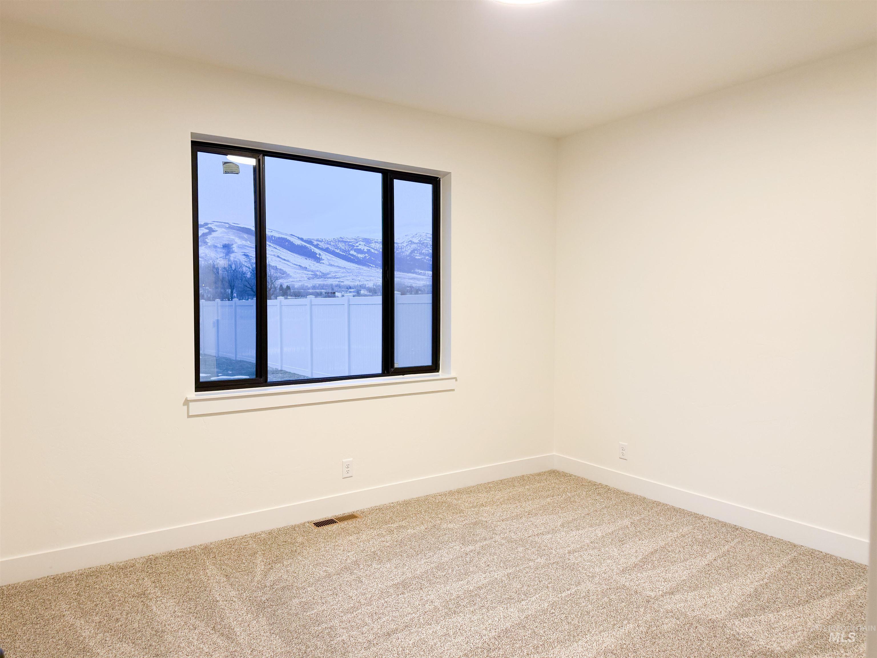 235 Whitman Street Albion, ID 83311 - Photo 7 of 23 Empty room featuring a mountain view and light carpet