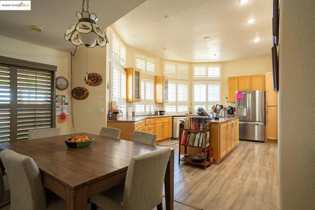 a view of a kitchen with kitchen island granite countertop wooden floor and stainless steel appliances