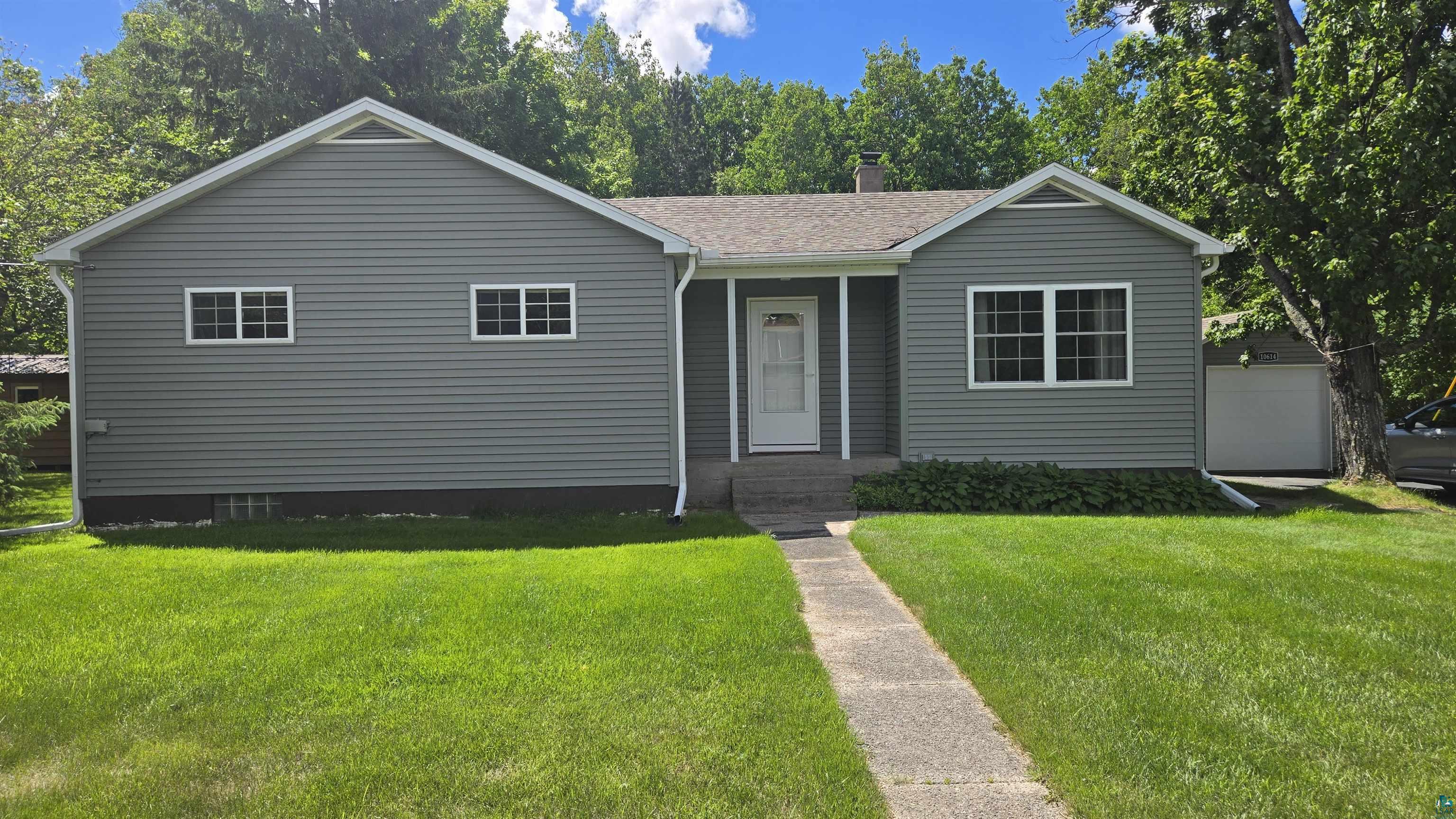 10614 Moose Lake Road Orr, MN 55771 - Photo 3 of 44 Single-story residence featuring grey horizontal siding, white trim, and a gabled roofline