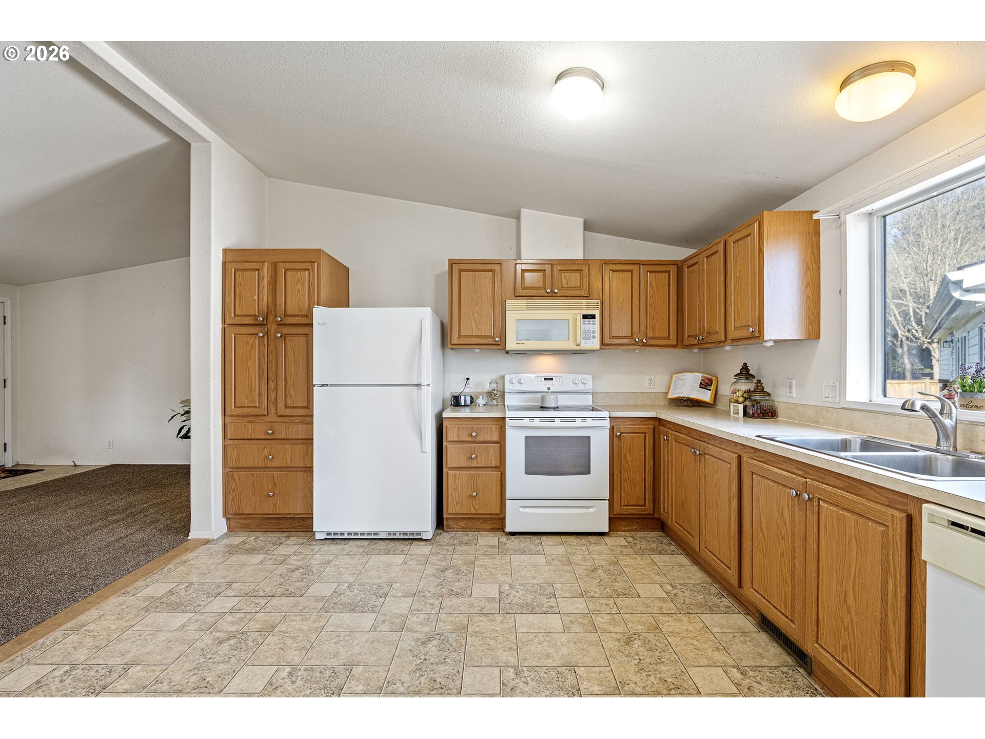 1699 North Terry Street, Unit 320 Eugene, OR 97402 - Photo 13 of 36 a kitchen with a refrigerator sink and cabinets