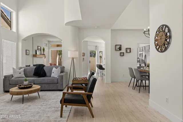 a living room with furniture a clock on wall and a window