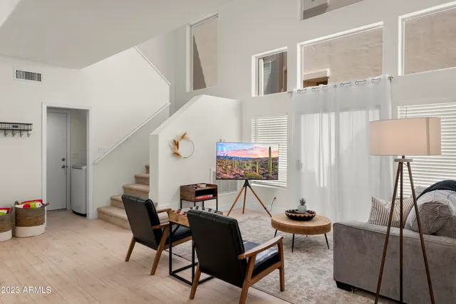 a living room with furniture a flat screen tv and a window