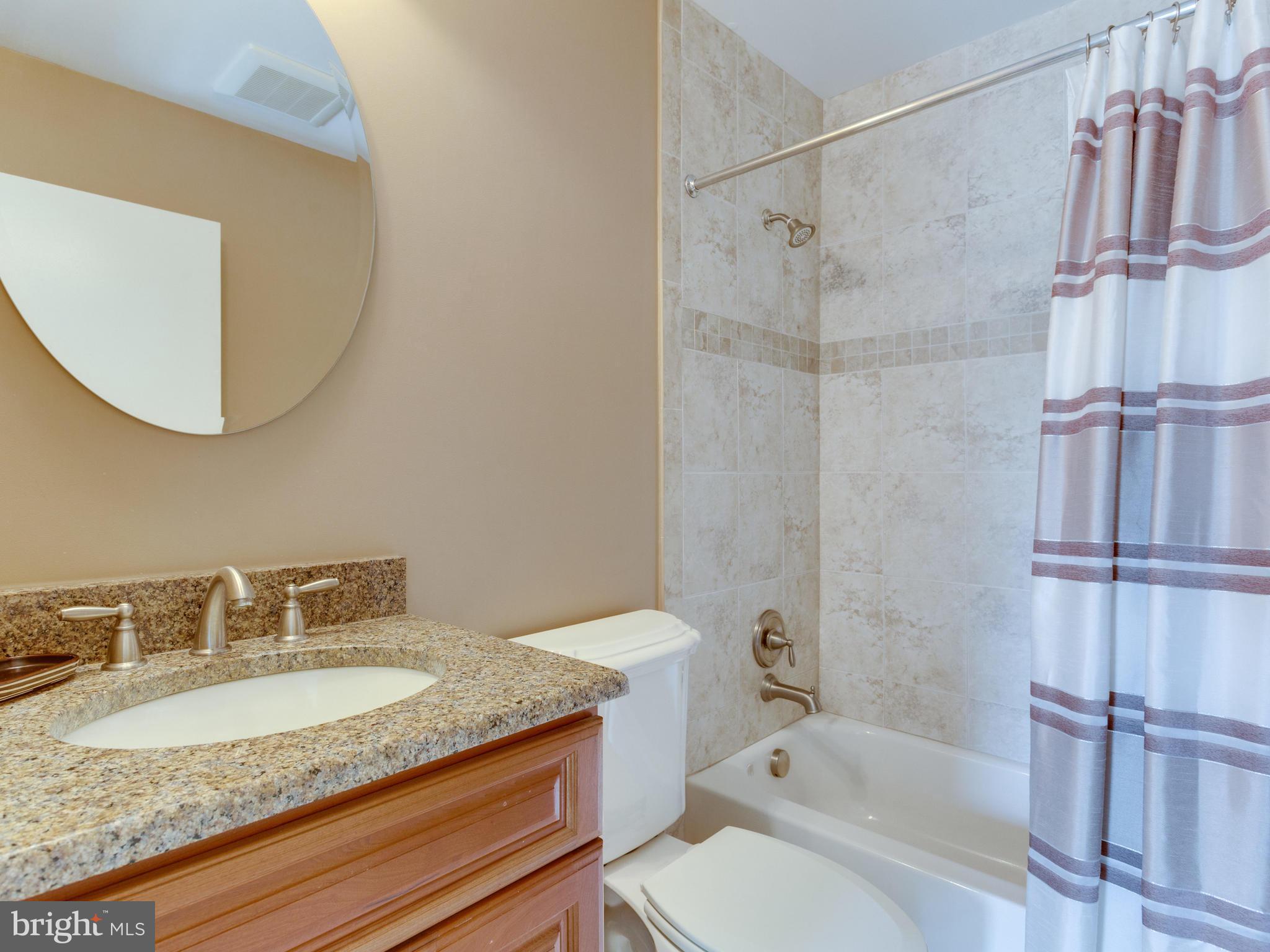 2072 Lake Audubon Court Reston, VA 20191 - Photo 20 of 30 a bathroom with a granite countertop sink toilet and shower