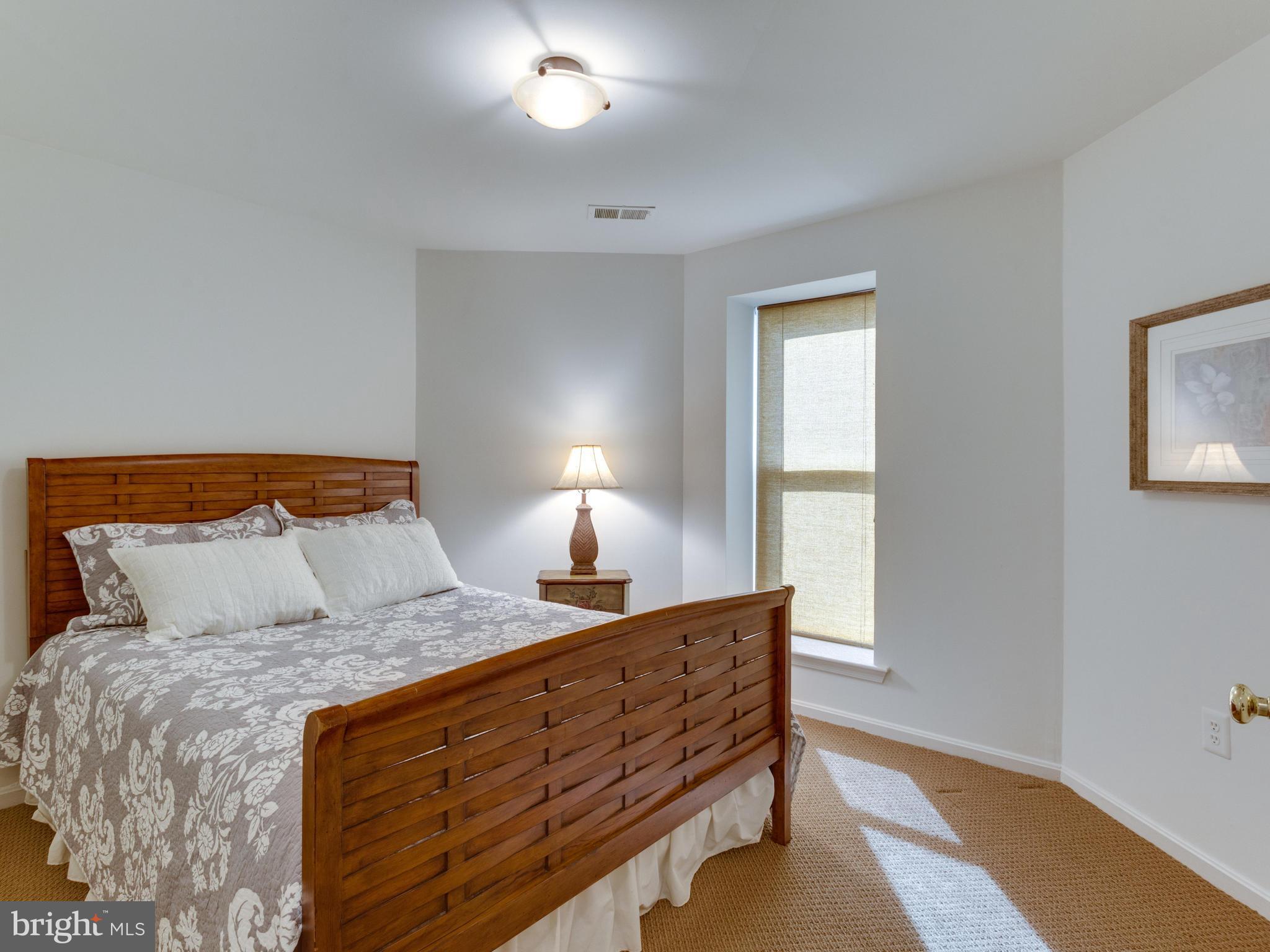 2072 Lake Audubon Court Reston, VA 20191 - Photo 22 of 30 a bedroom with a bed and a lamp on dresser