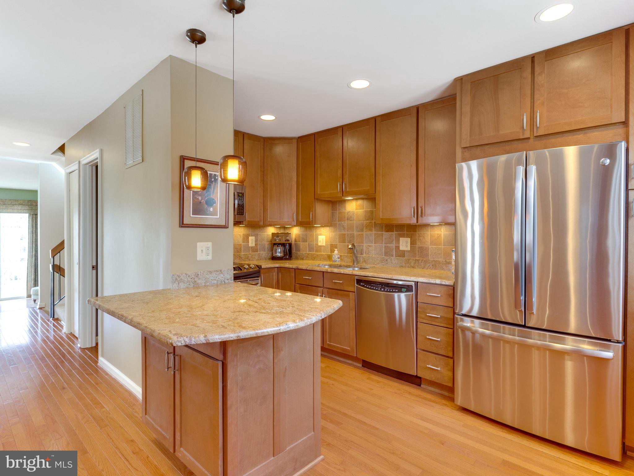 2072 Lake Audubon Court Reston, VA 20191 - Photo 5 of 30 a kitchen with stainless steel appliances granite countertop a refrigerator a sink dishwasher and a stove with wooden floor
