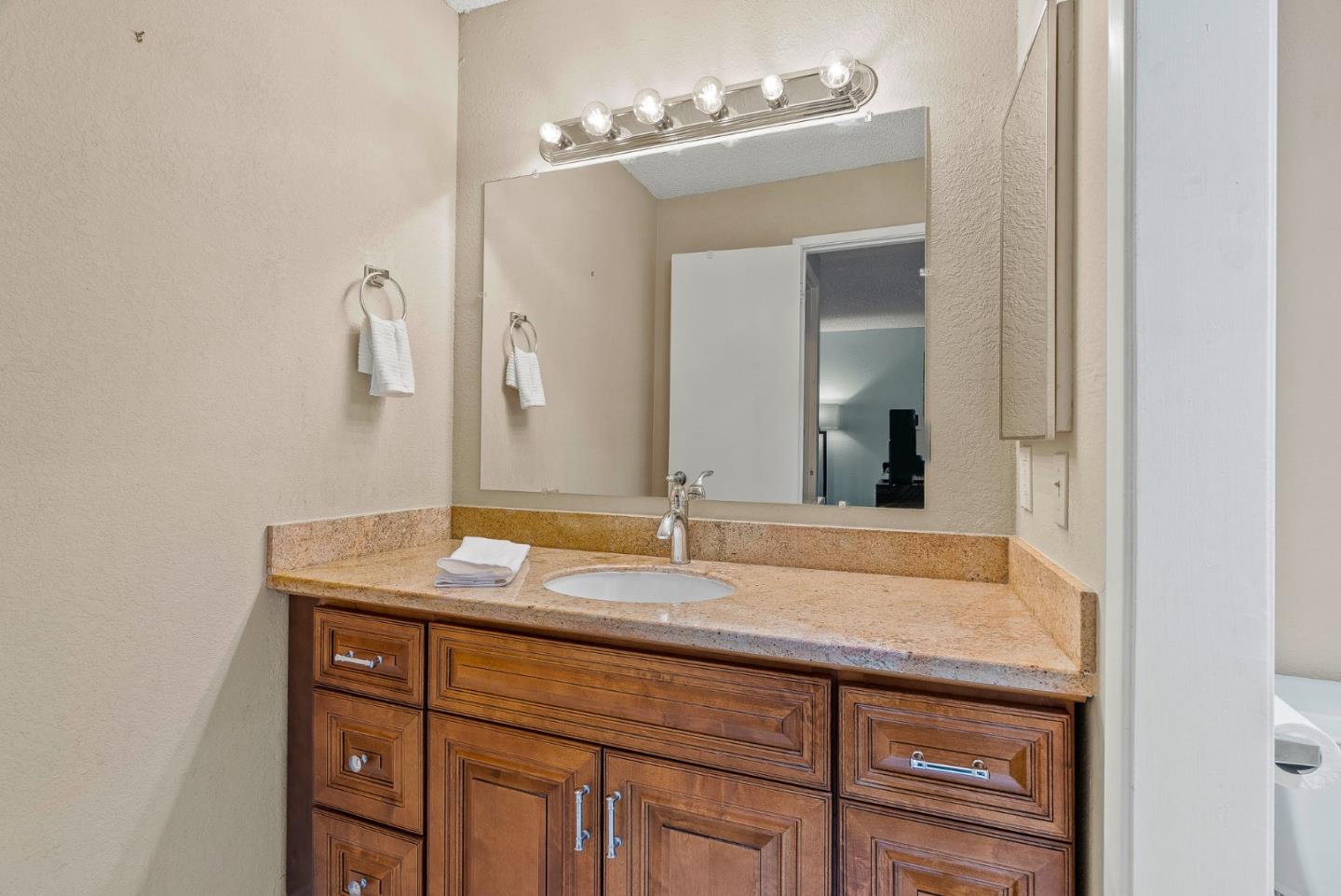 230 Stonegate Circle San Jose, CA 95110 - Photo 12 of 18 a bathroom with a granite countertop sink and a mirror