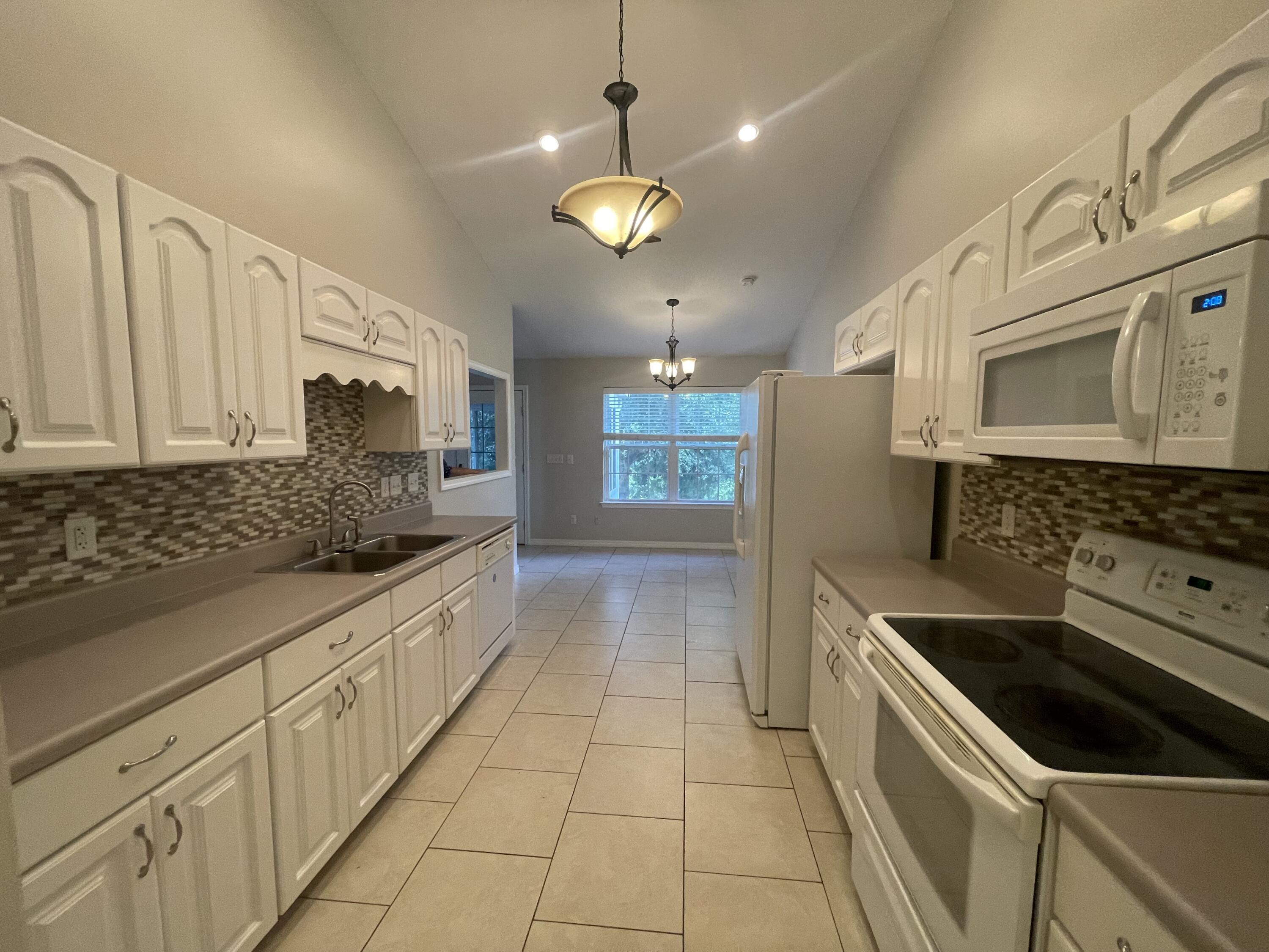 728 Riva Ridge Drive Crestview, FL 32539 - Photo 7 of 26 a kitchen with stainless steel appliances granite countertop a stove a sink and a microwave