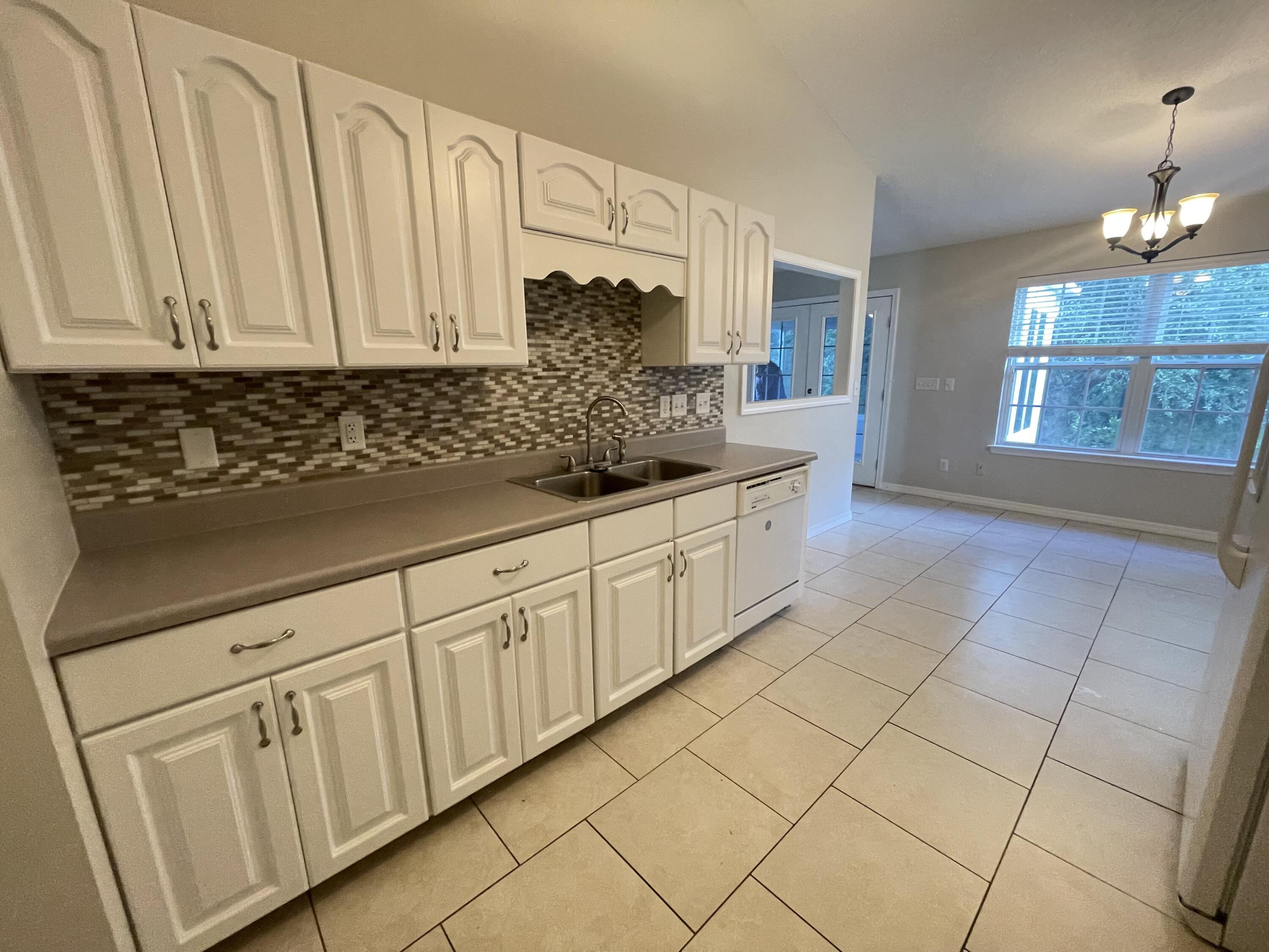 728 Riva Ridge Drive Crestview, FL 32539 - Photo 9 of 26 a kitchen with stainless steel appliances a sink dishwasher and white cabinets with wooden floor